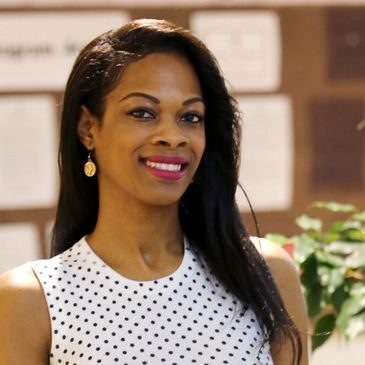 A woman in white polka dot top smiling for the camera.